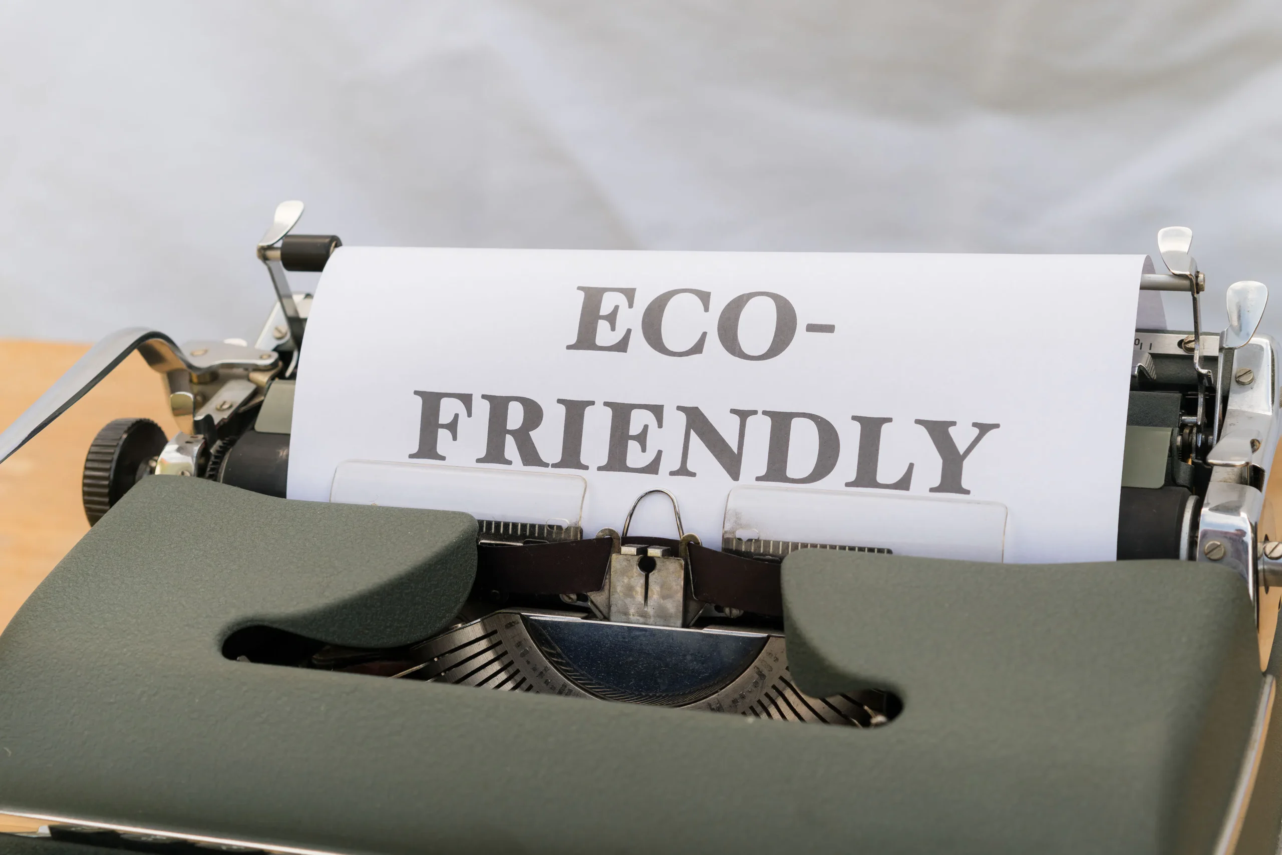A vintage typewriter with the words 'ECO-FRIENDLY' typed on a sheet of paper, emphasizing the importance of environmentally conscious content creation and AI for bloggers.