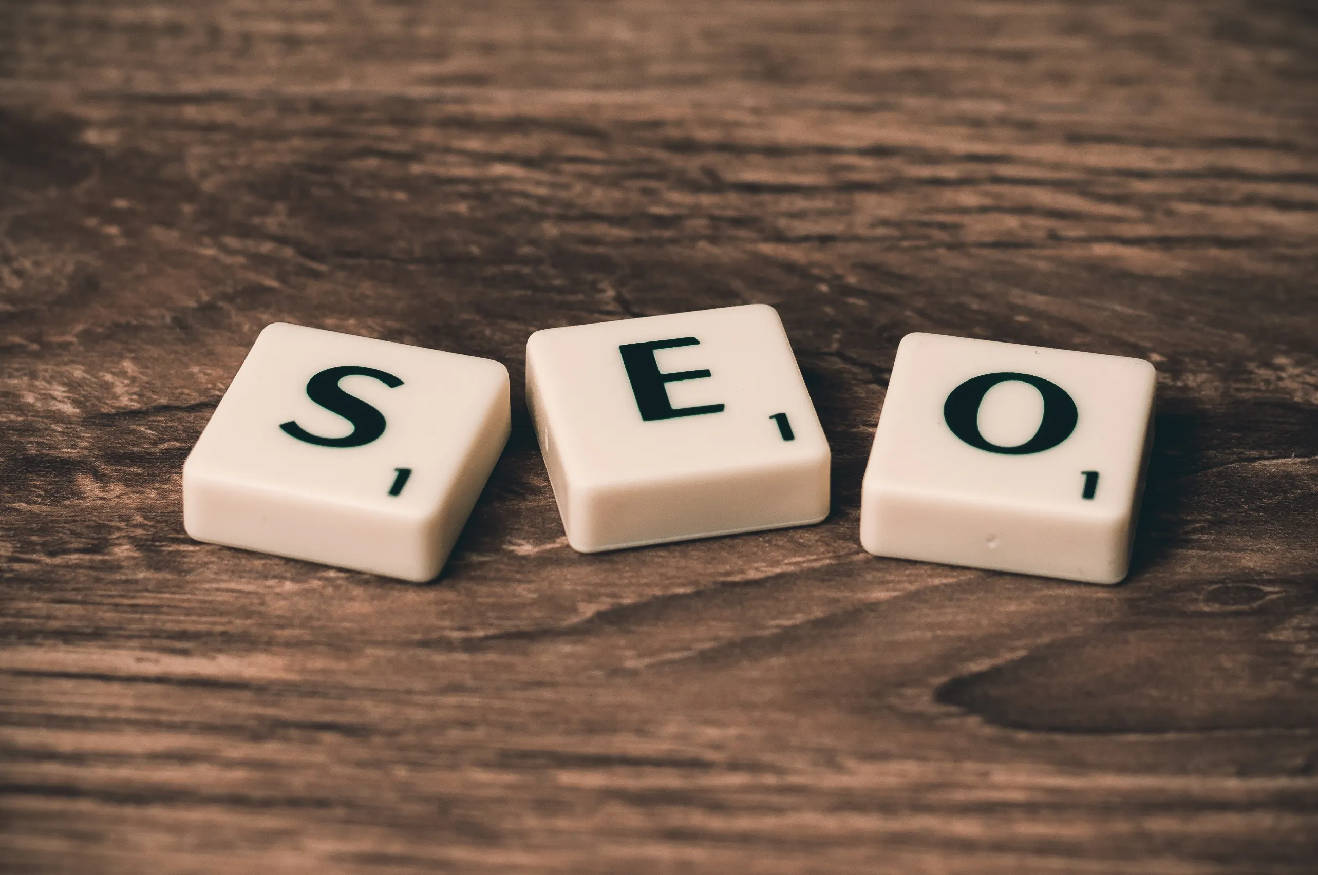 Close-up of Scrabble tiles spelling out 'SEO,' emphasizing the importance of search engine optimization for increasing blog visibility and utilizing AI writing tips to improve SEO blog writing.