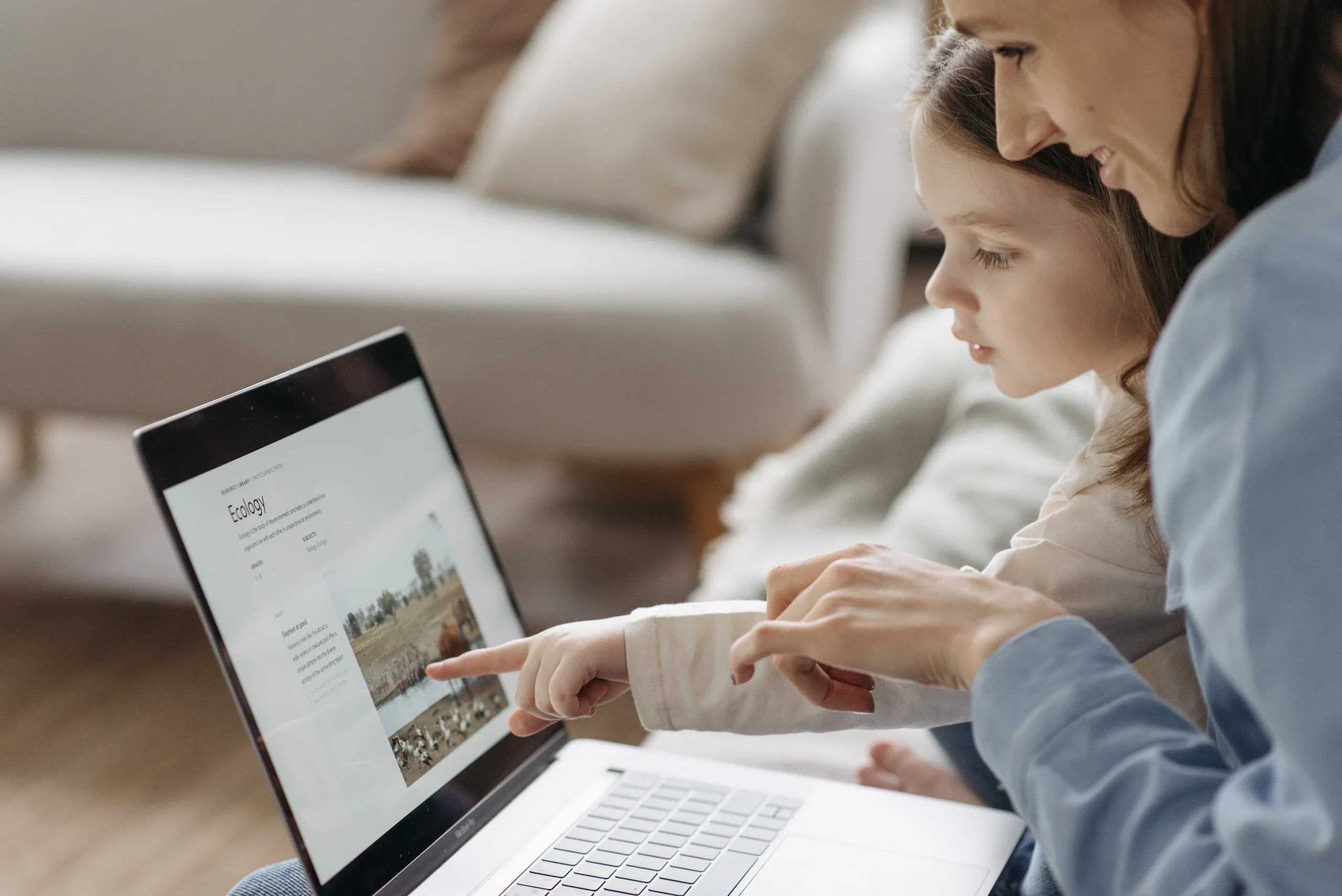 A mother and daughter looking at a laptop screen together, potentially exploring blog post ideas or using AI for bloggers to enhance their content strategy.