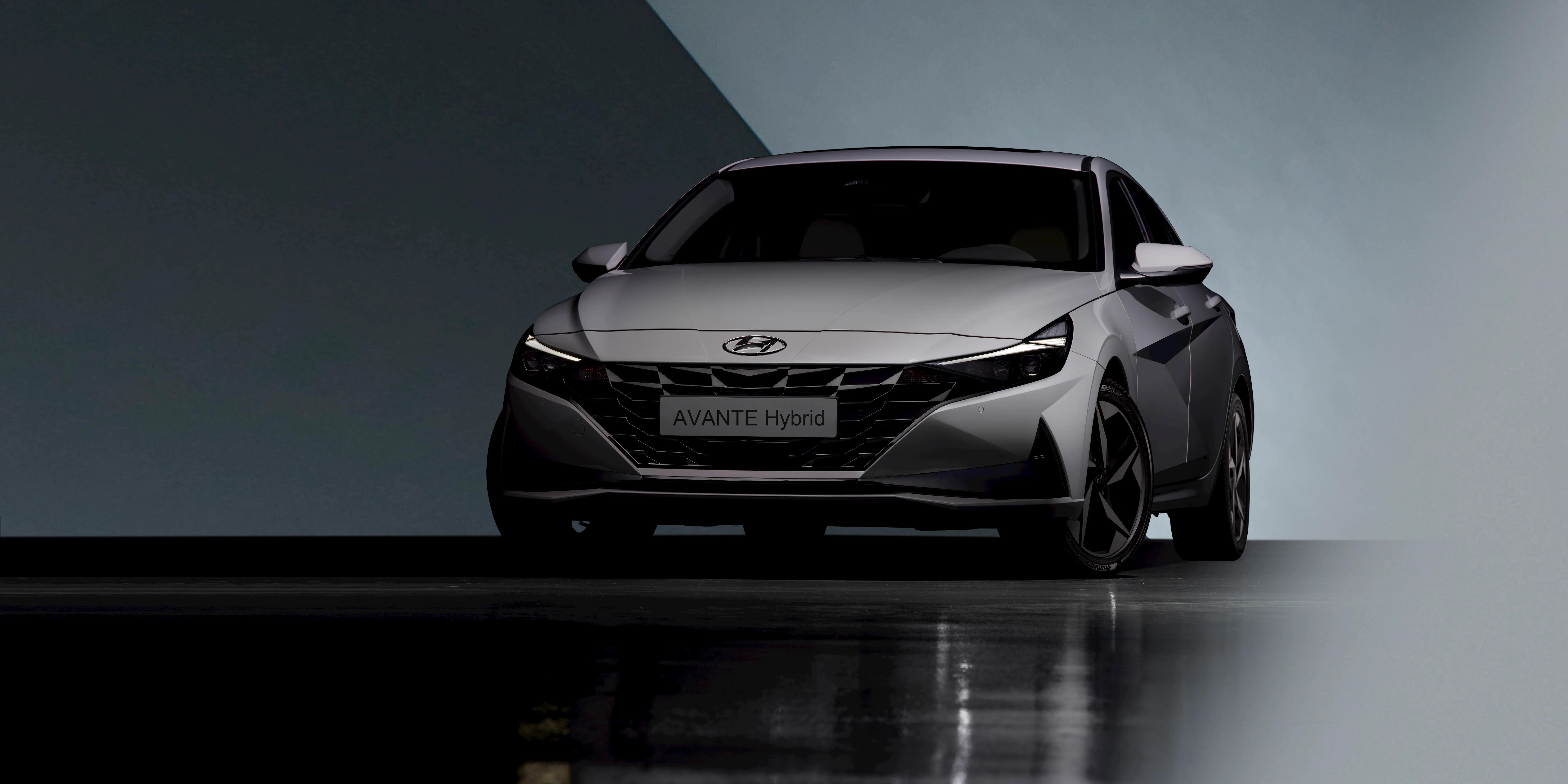 Front view of a silver Hyundai Avante Hybrid car in a studio setting.