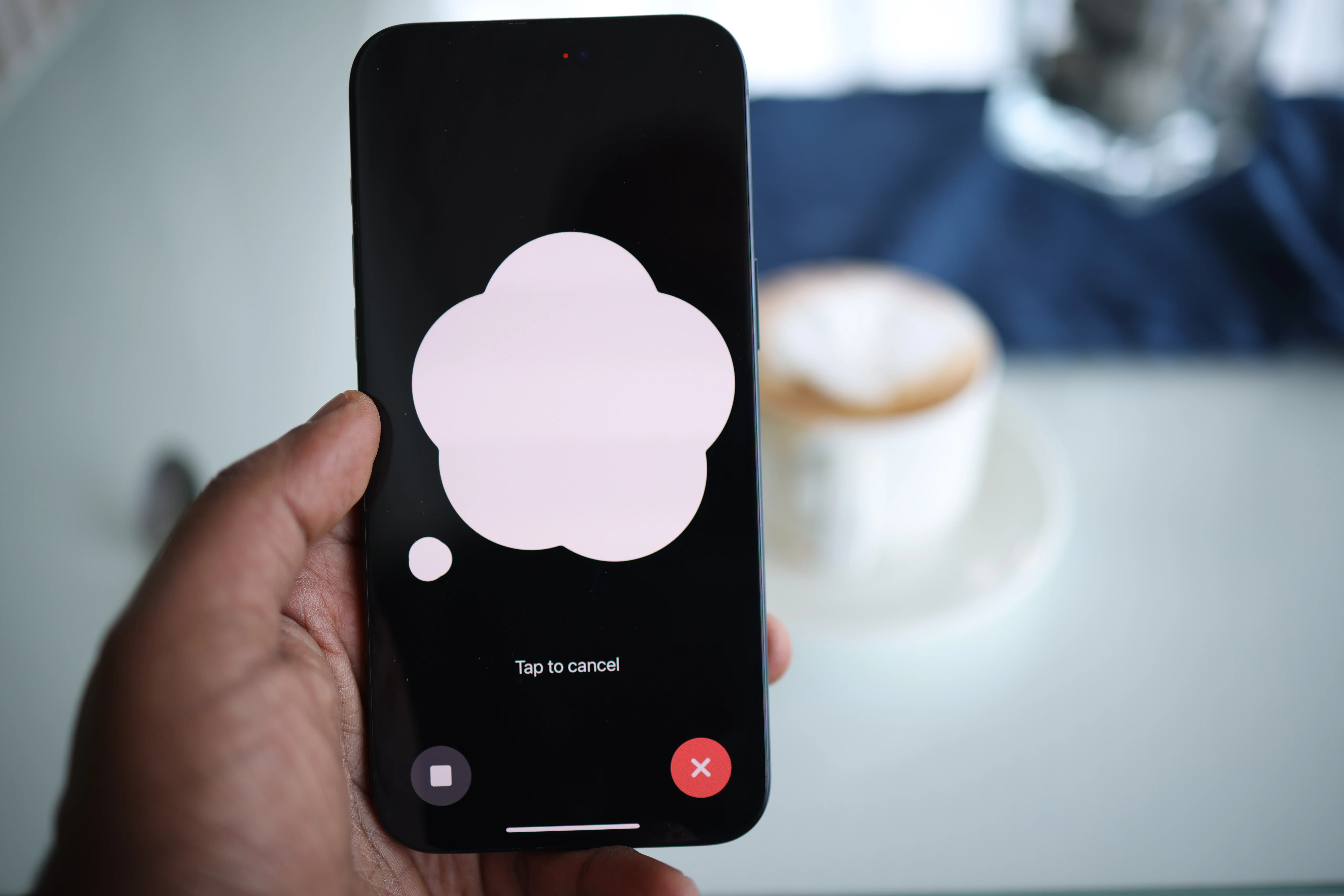 Hand holding iPhone with a blank thought bubble on screen