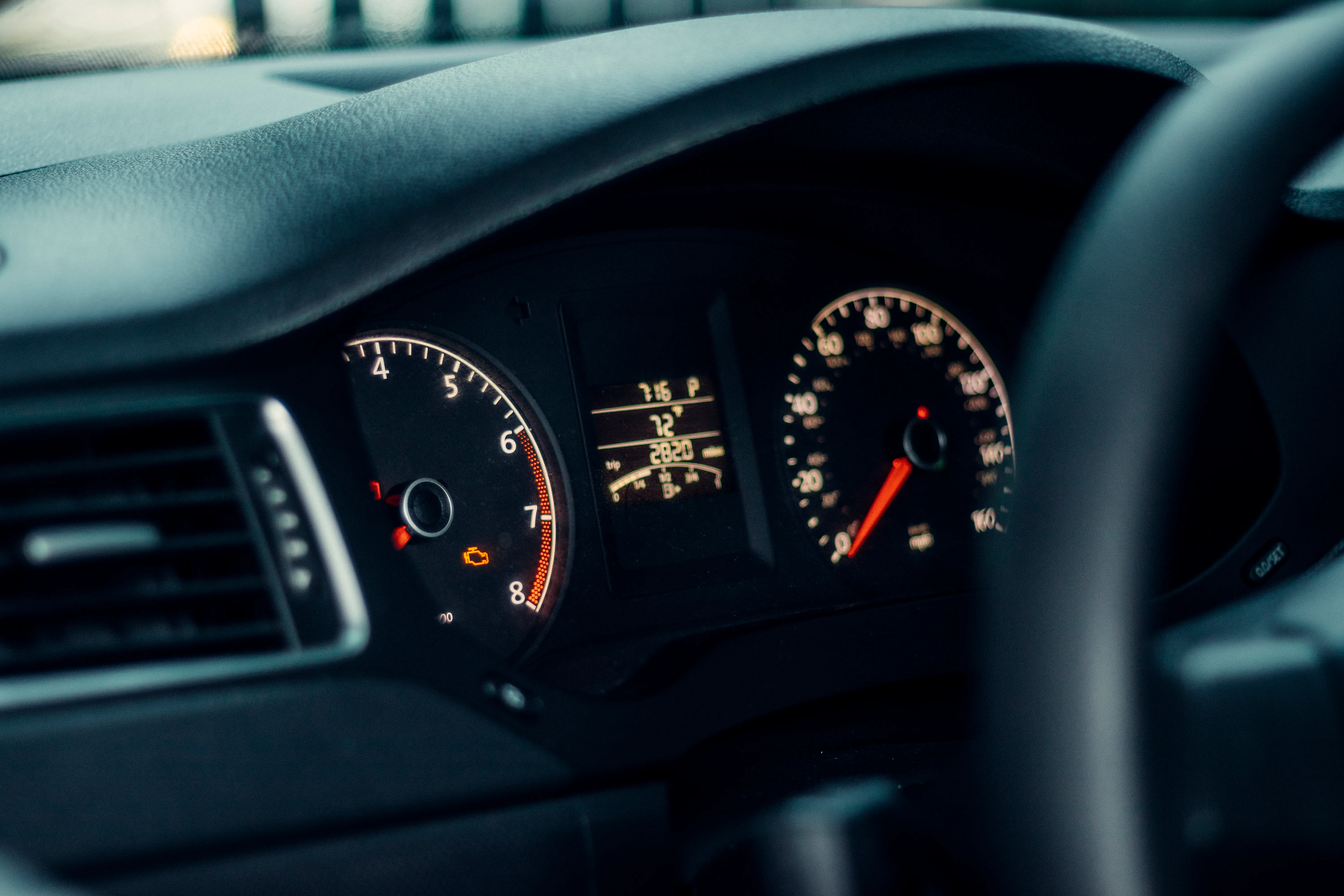 Car dashboard with speedometer, tachometer, and digital display showing vehicle information.
