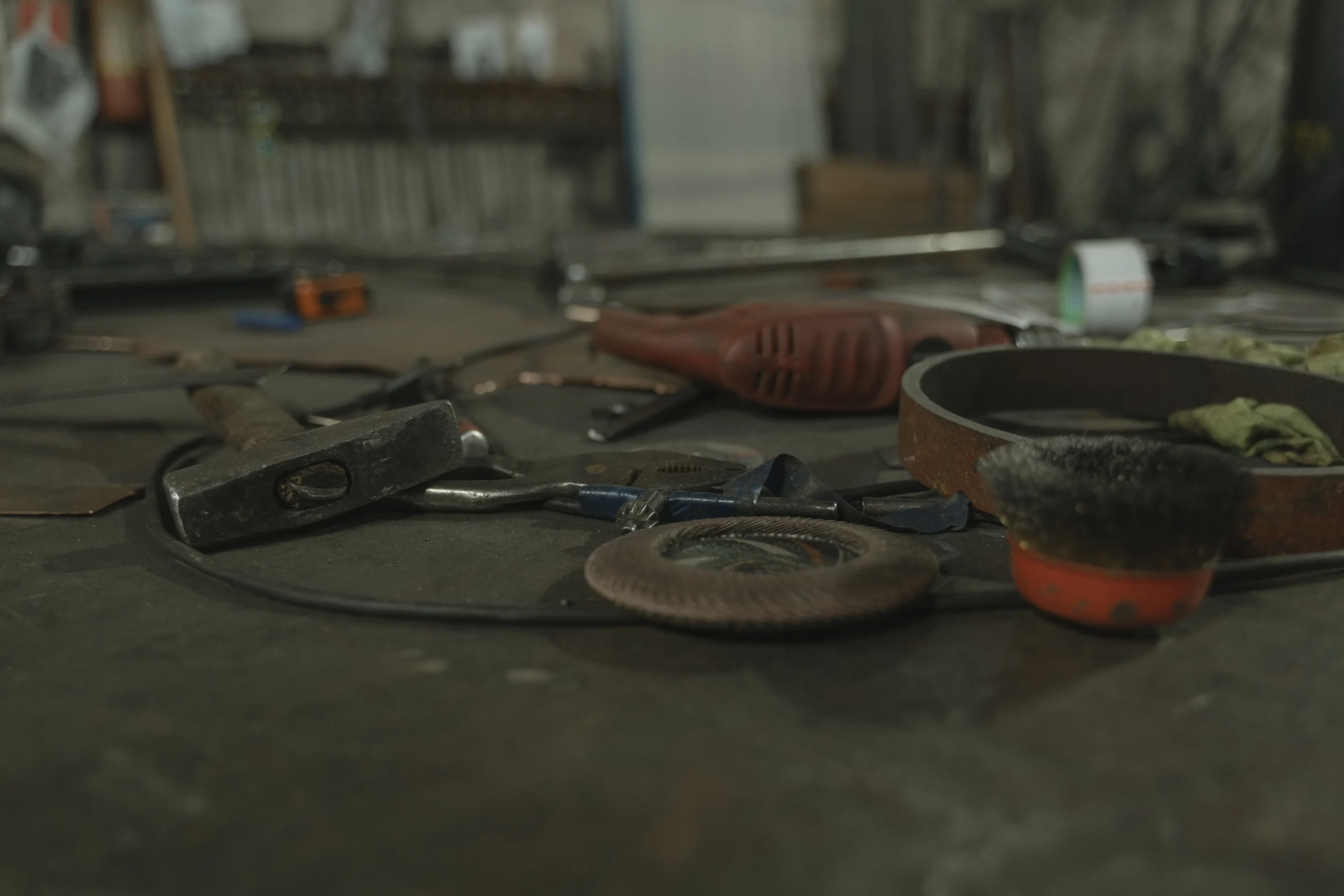 Close-up of various metalworking tools scattered on a workbench.