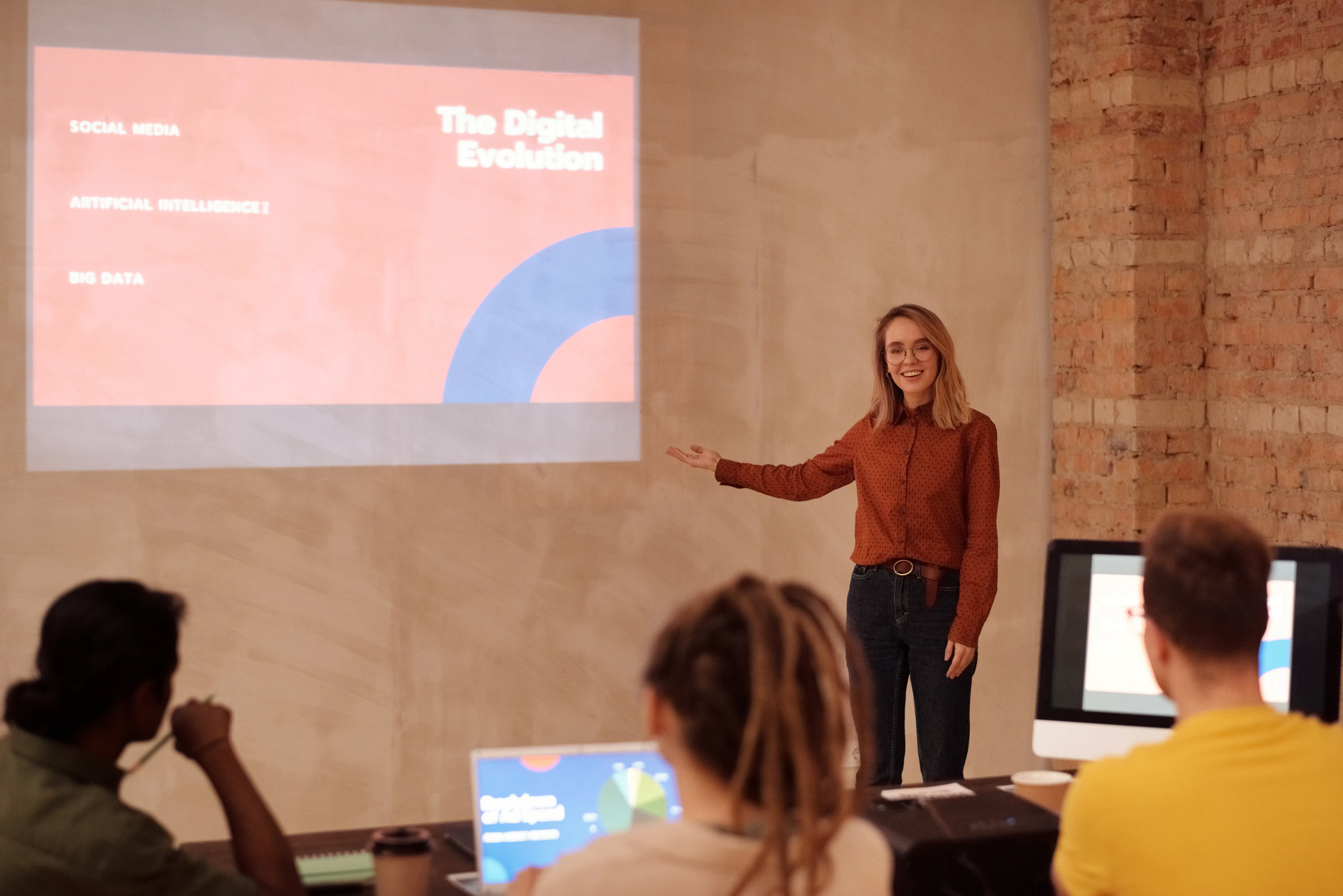 Woman presenting 'The Digital Evolution' including artificial intelligence to a class.
