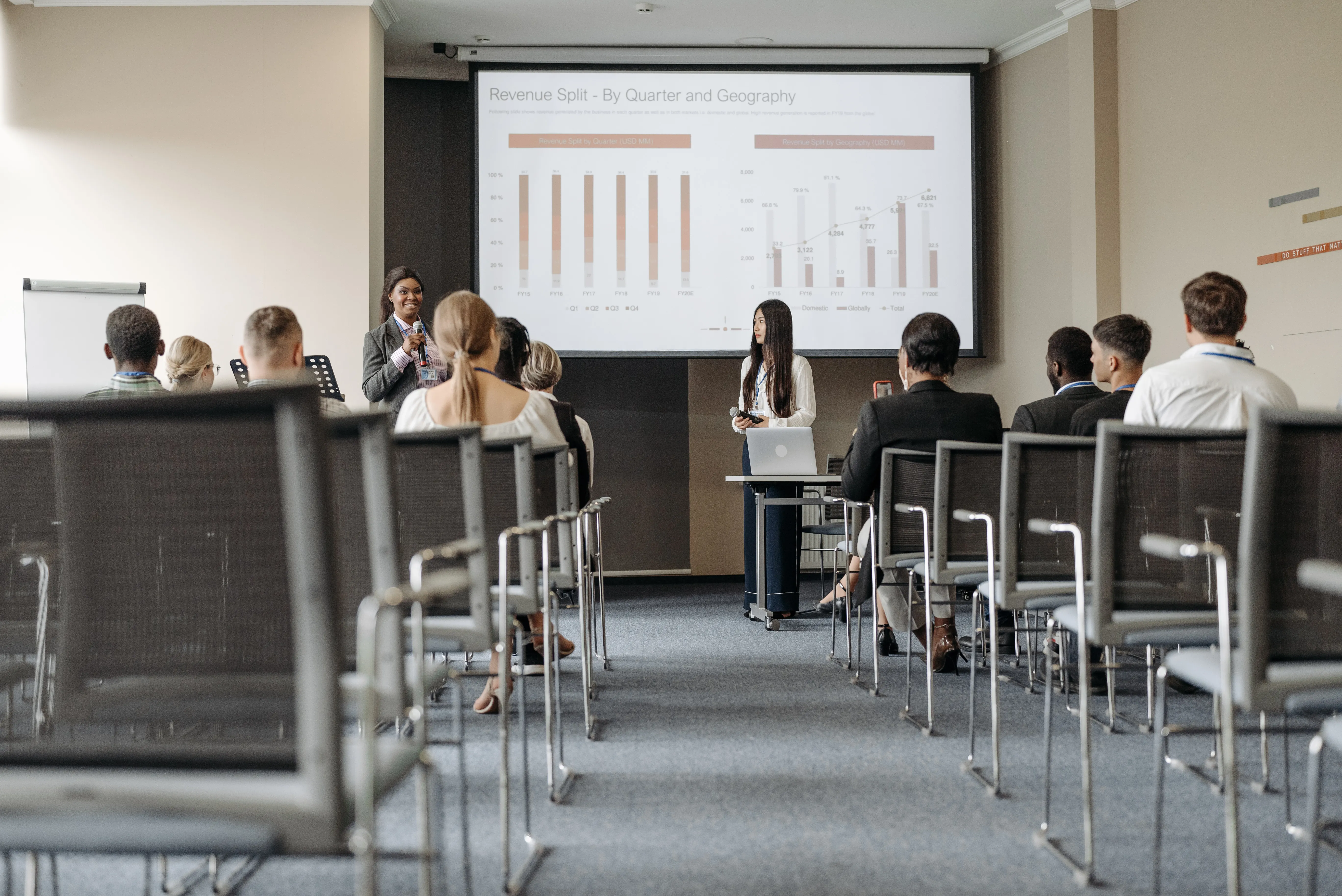 Audience watching presentation on revenue split by quarter and geography.