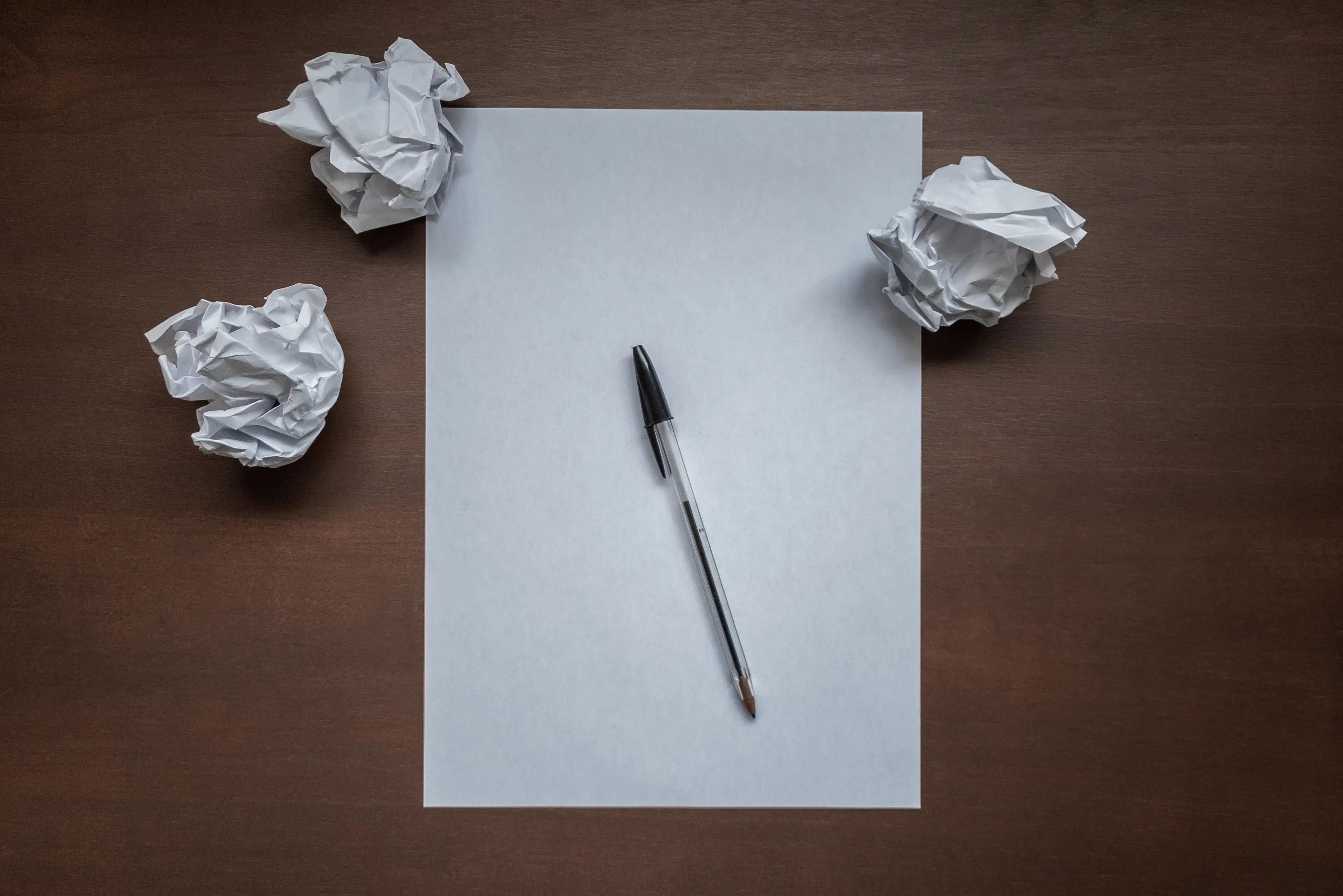 Blank page with pen and crumpled paper, representing the start of AI blog post creation.