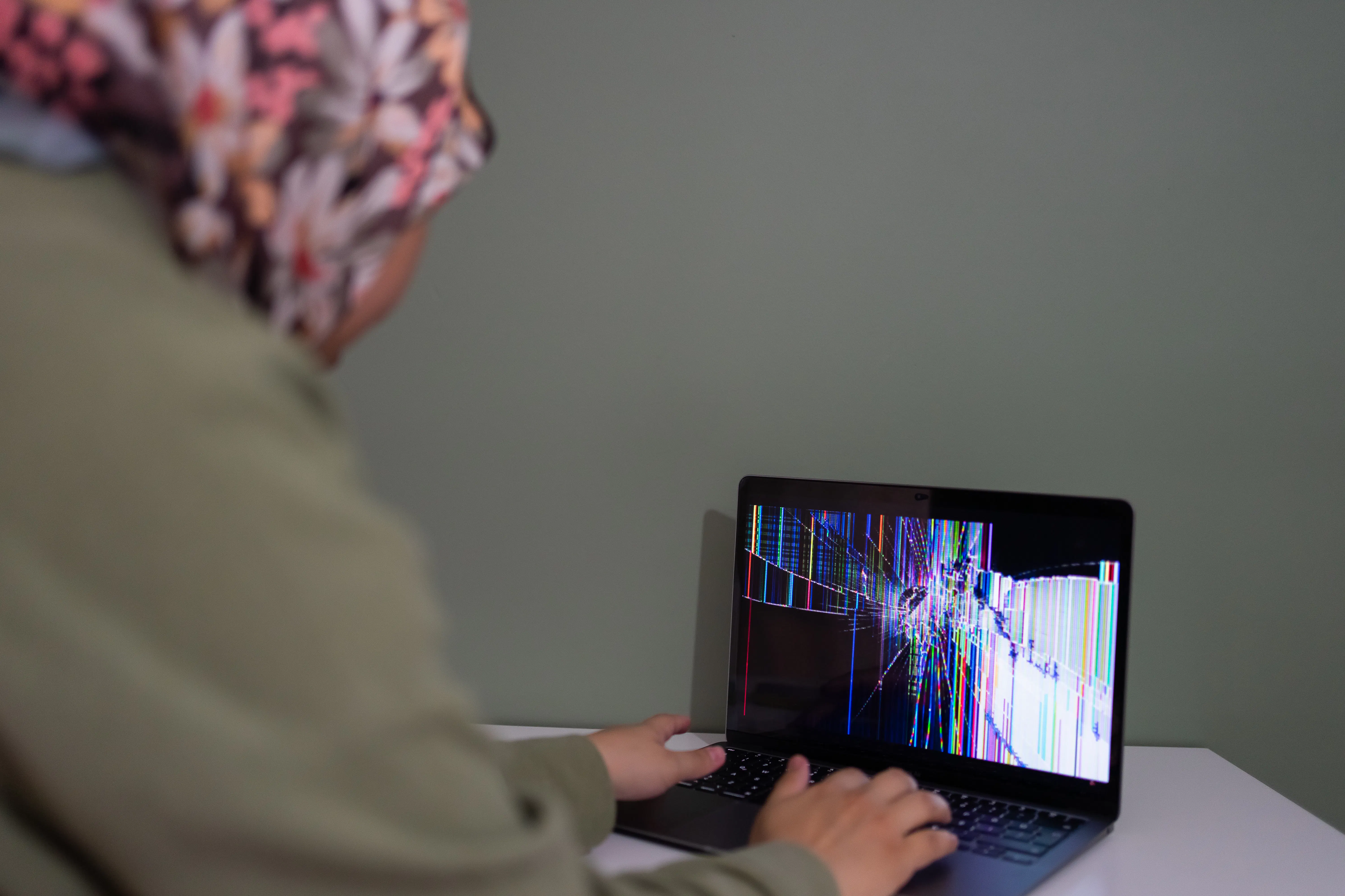 Person using a broken laptop screen, representing AI content risks and potential blog traffic decline.
