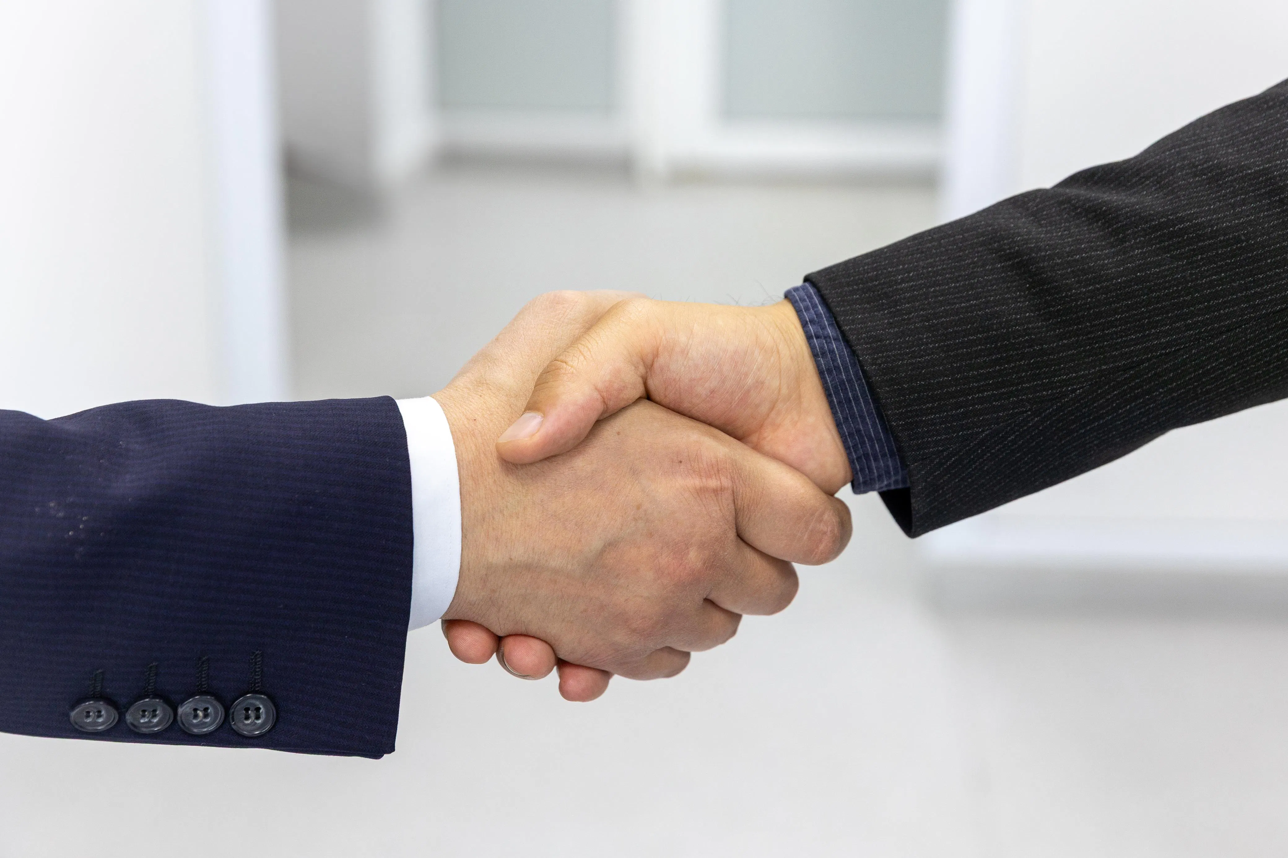 Two business people shaking hands, symbolizing safe content automation and avoiding SEO penalties.