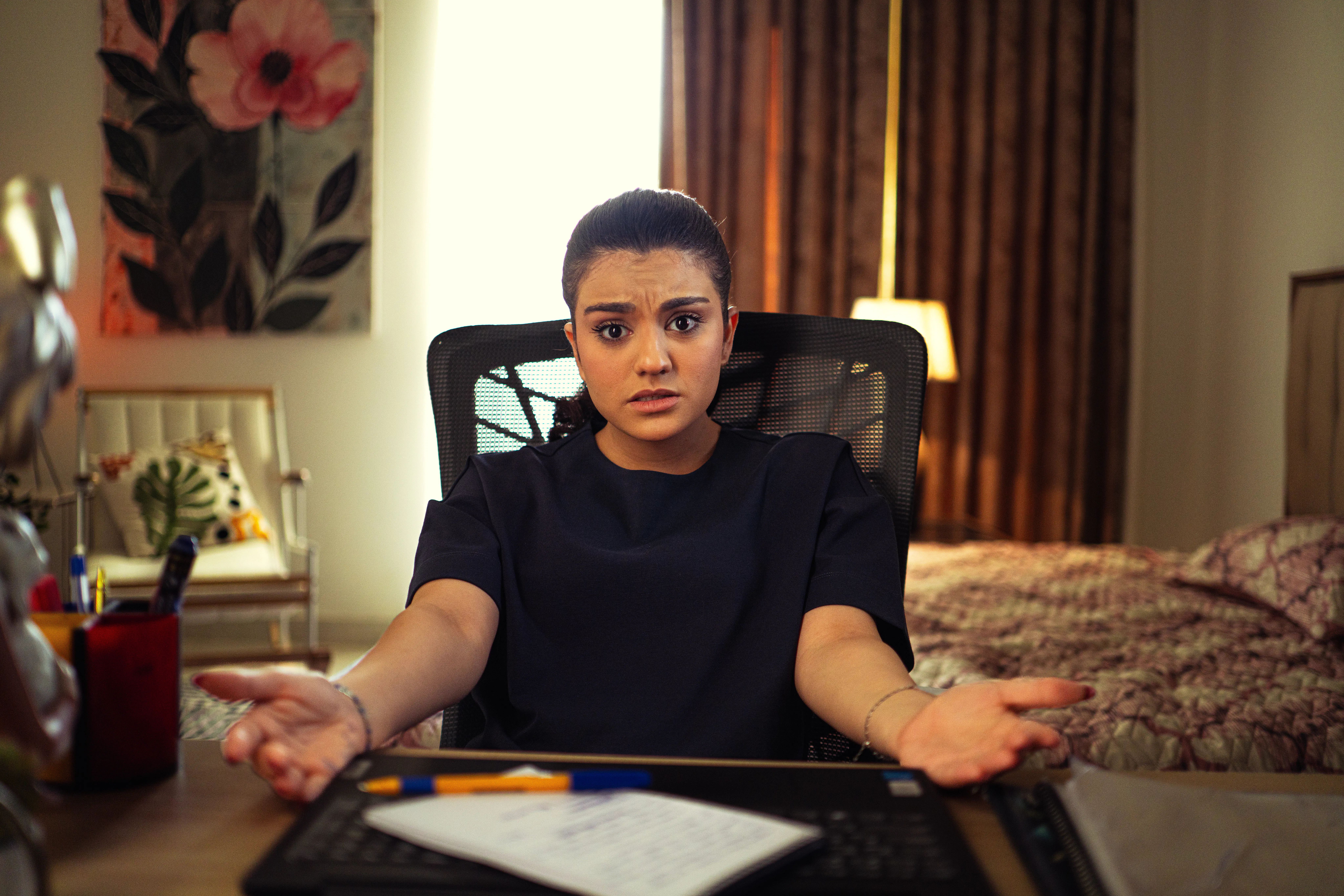 A woman looking confused at her laptop, needing an AI writing tool to scale content production efficiently.