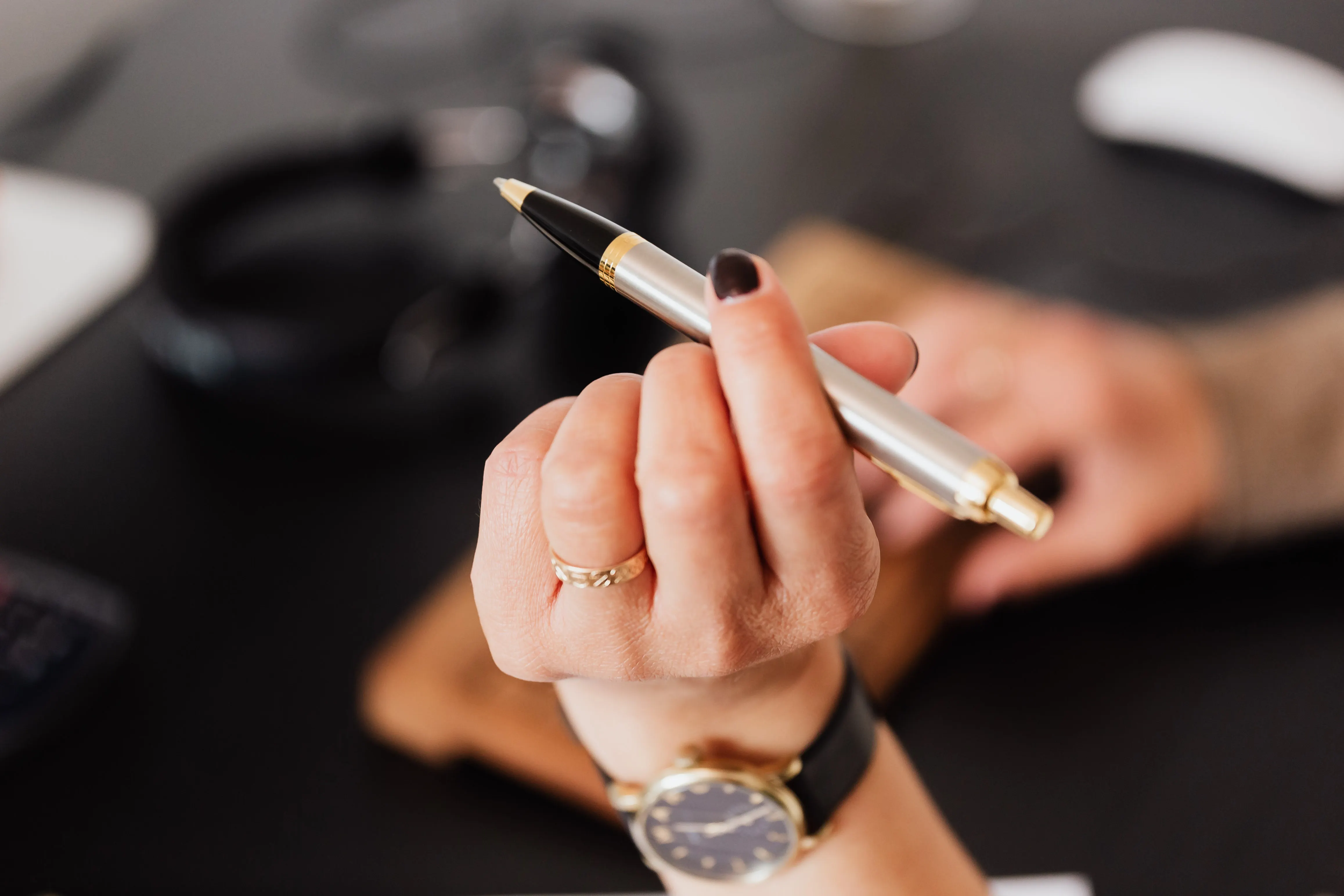 Hand holding a pen, representing the shift from manual drafts to an AI seo article writer.