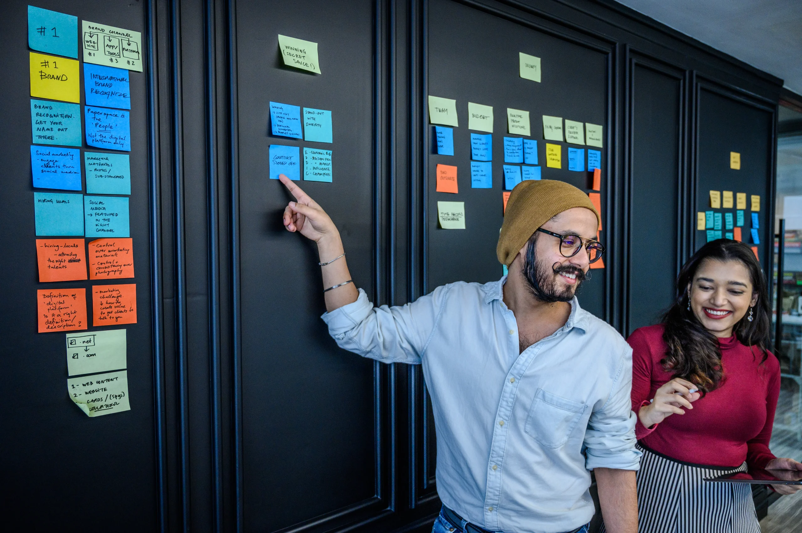 Marketing team using content automation platforms to organize strategy with sticky notes on a wall.