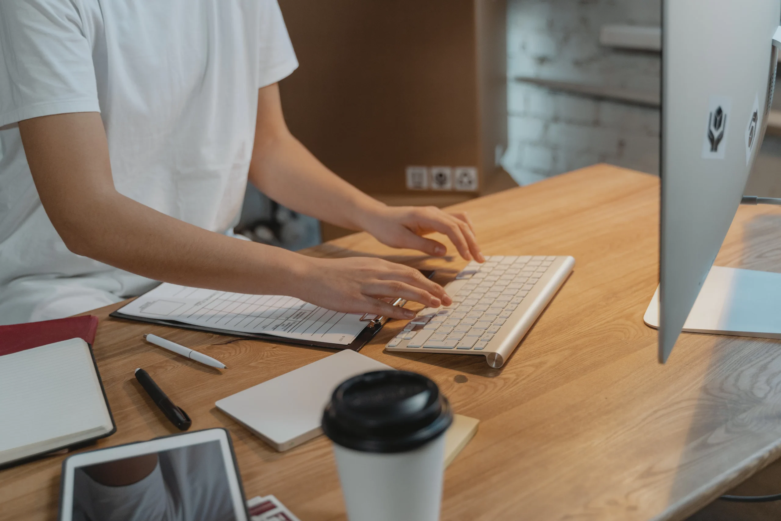 Person typing on a keyboard, using an seo content generator tool to improve organic traffic growth.