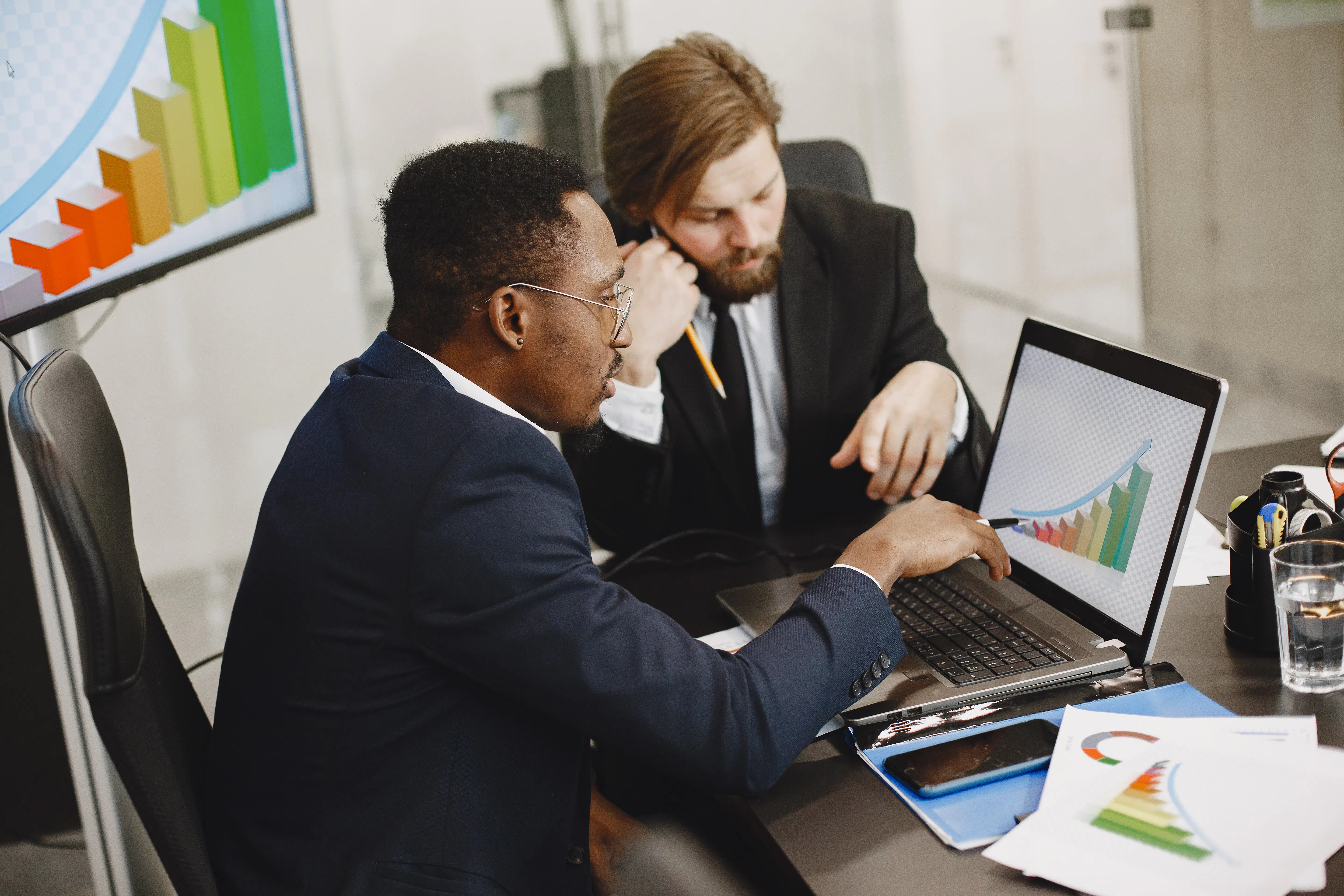 Business professionals analyzing organic traffic growth data on a laptop for better SEO tool ROI.