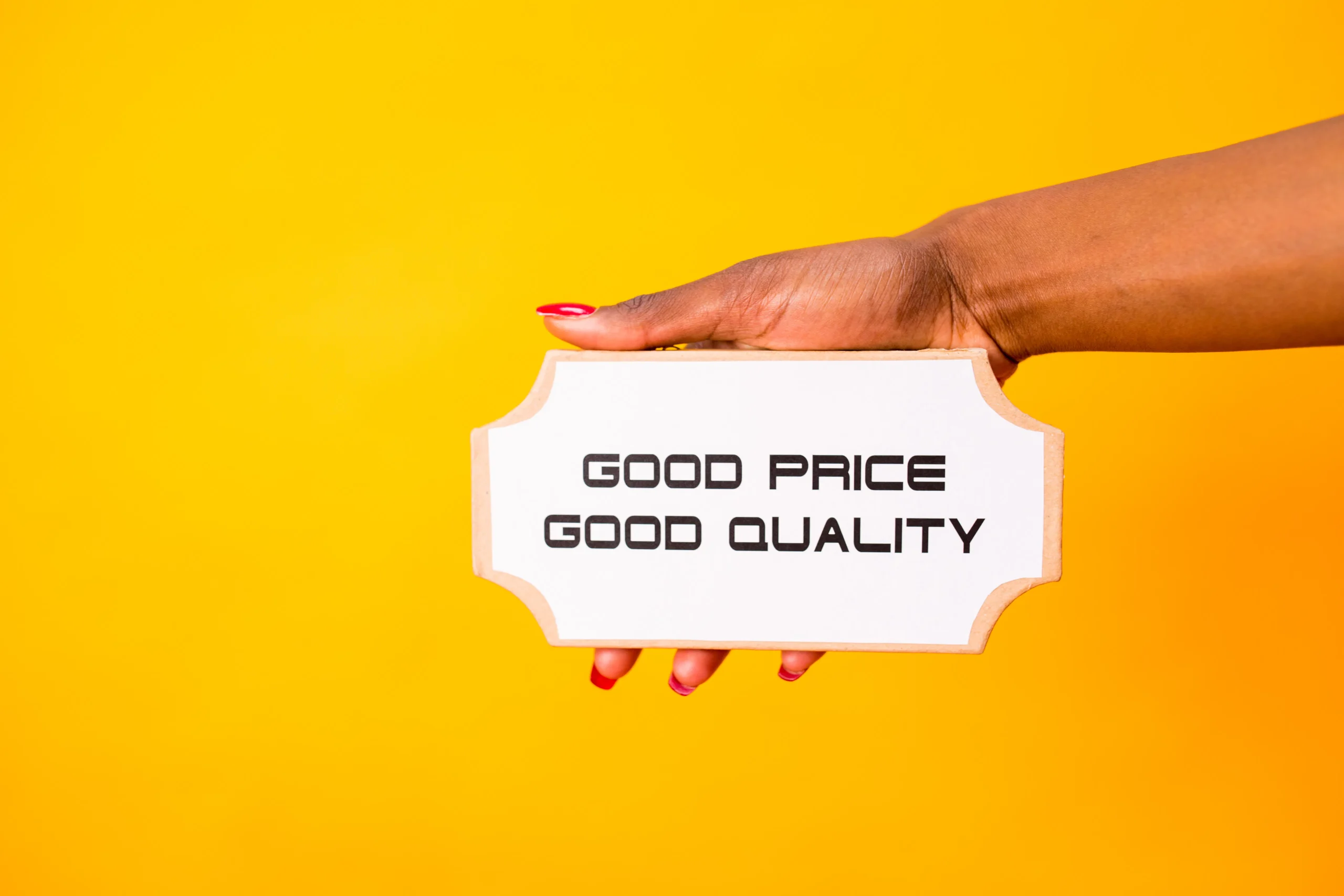 A hand holding a sign saying Good Price Good Quality, reflecting Google quality guidelines for content.