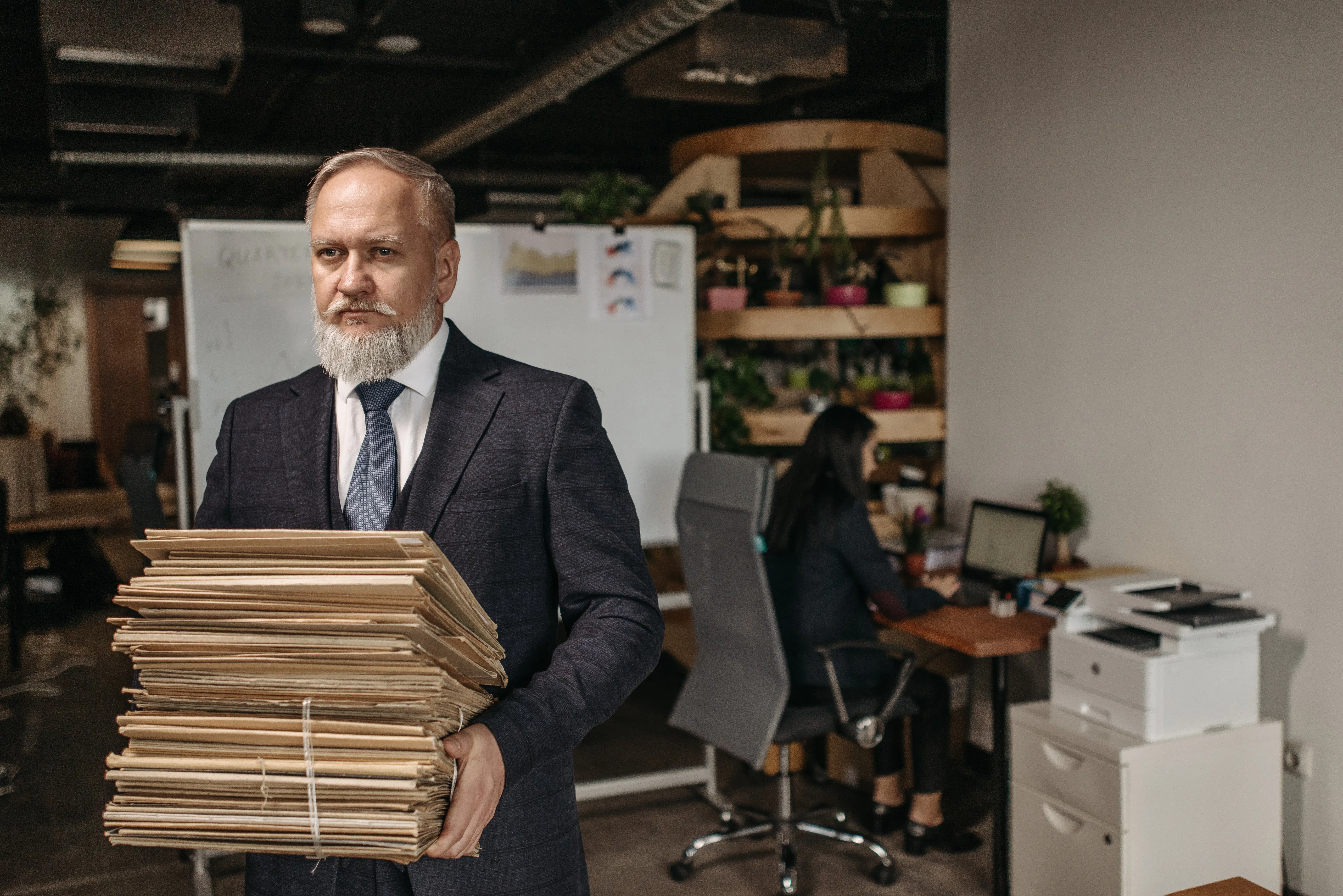 A man holding a stack of files, representing the need for marketing automation software to improve efficiency.