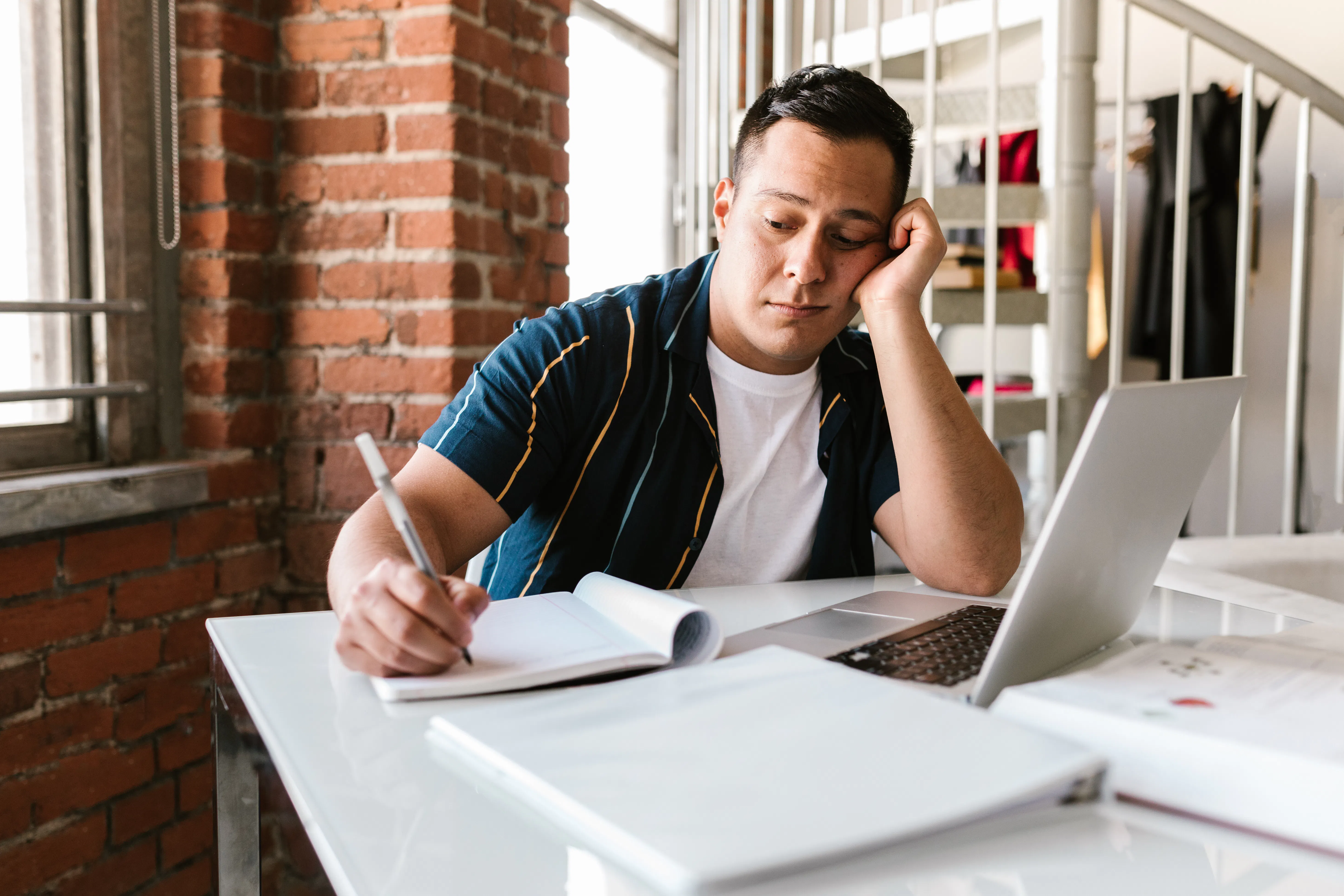 Man writing while using an ai content generator to improve his writing process.