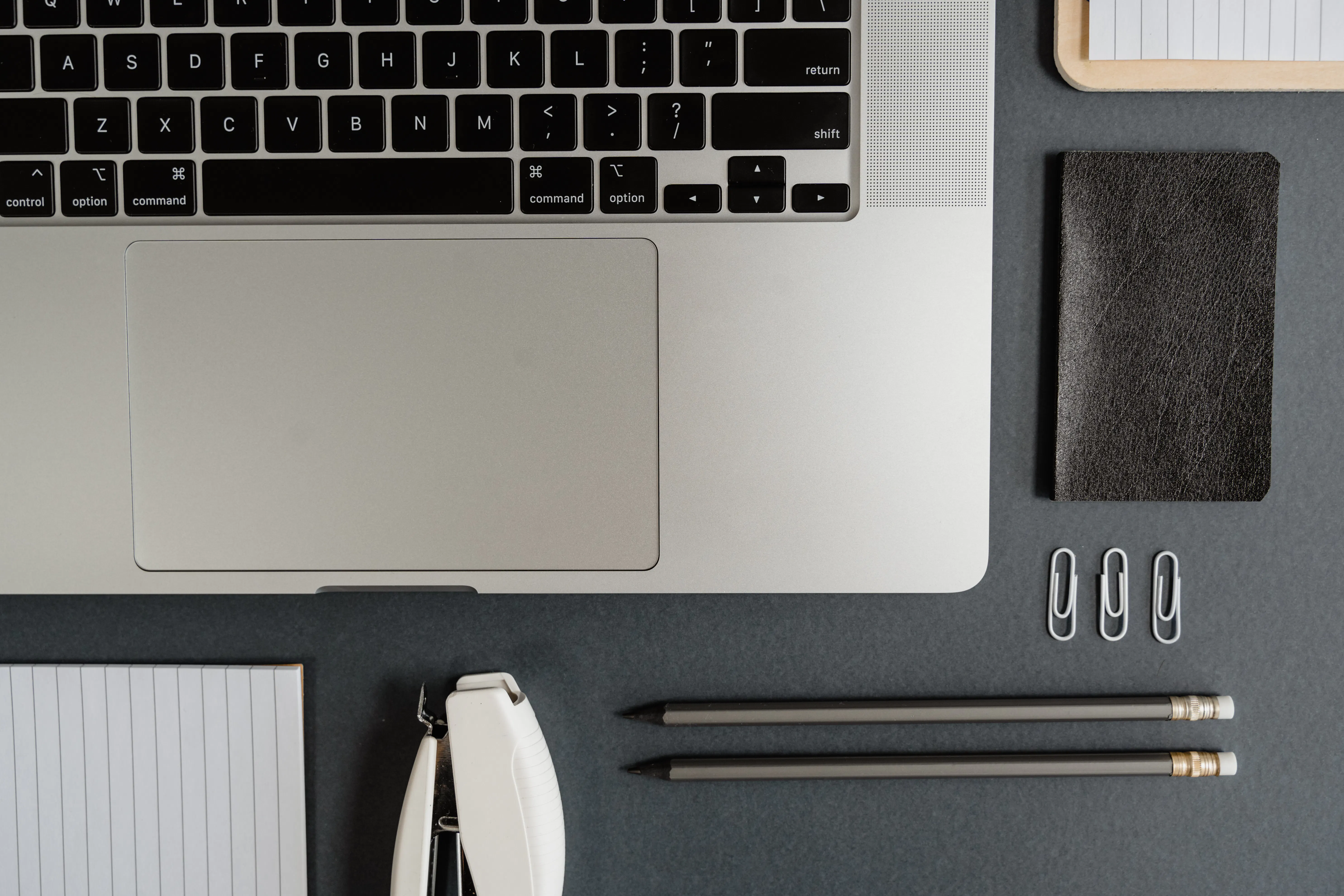 A laptop and stationery on a desk, perfect for using an seo friendly content generator for blog growth.