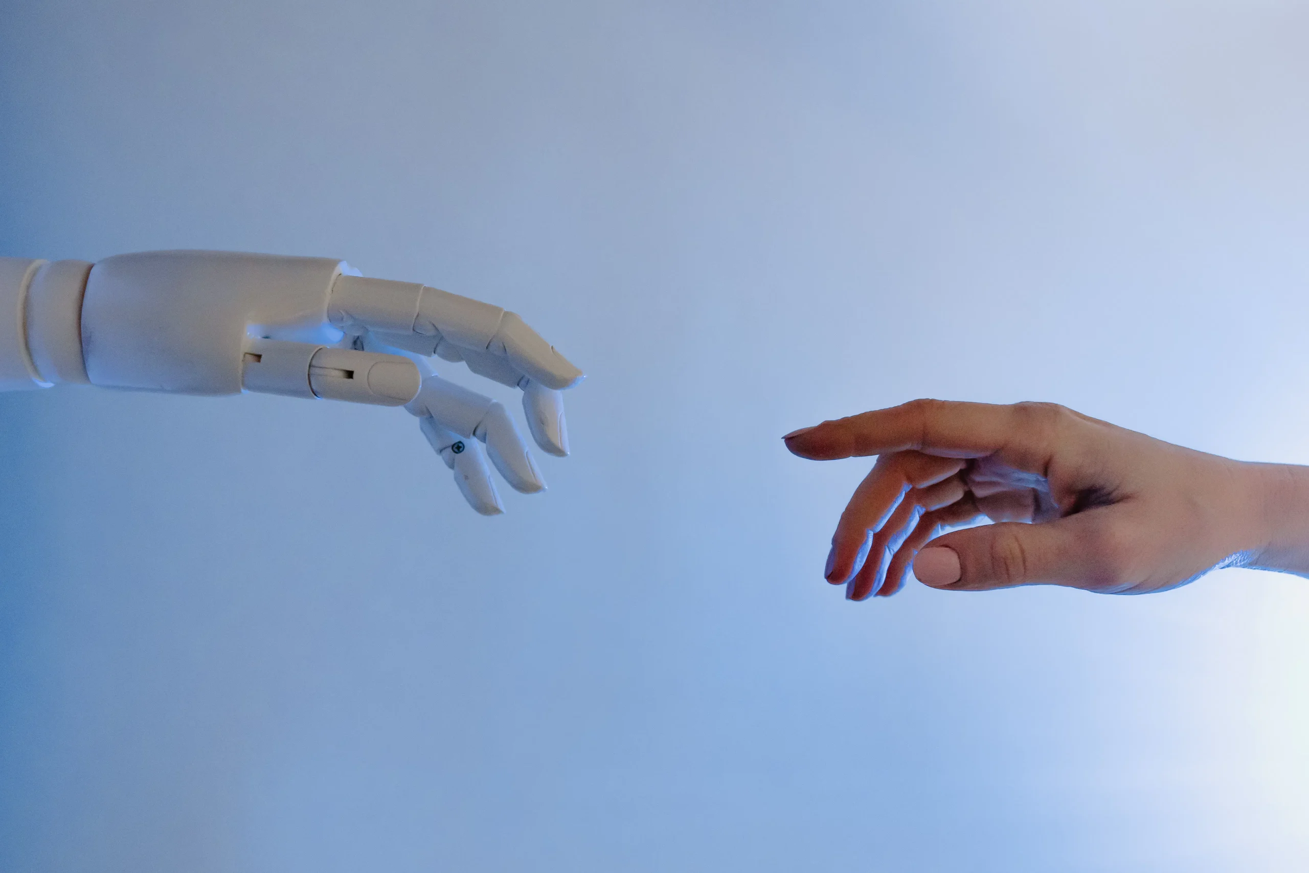 A robotic hand reaching toward a human hand, illustrating the balance of AI and human brand authority.