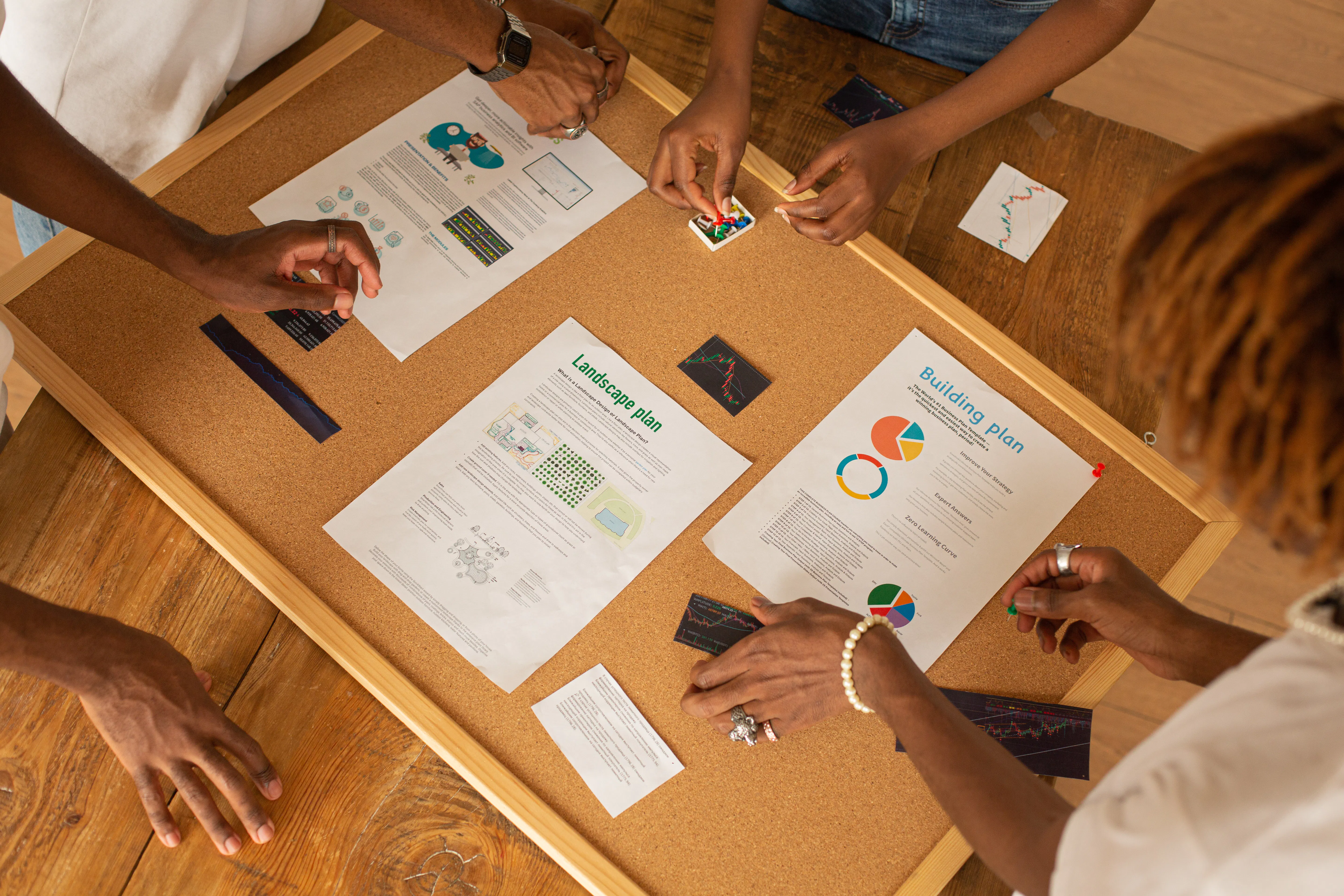 Team using an ai content generator to plan projects on a corkboard with charts.