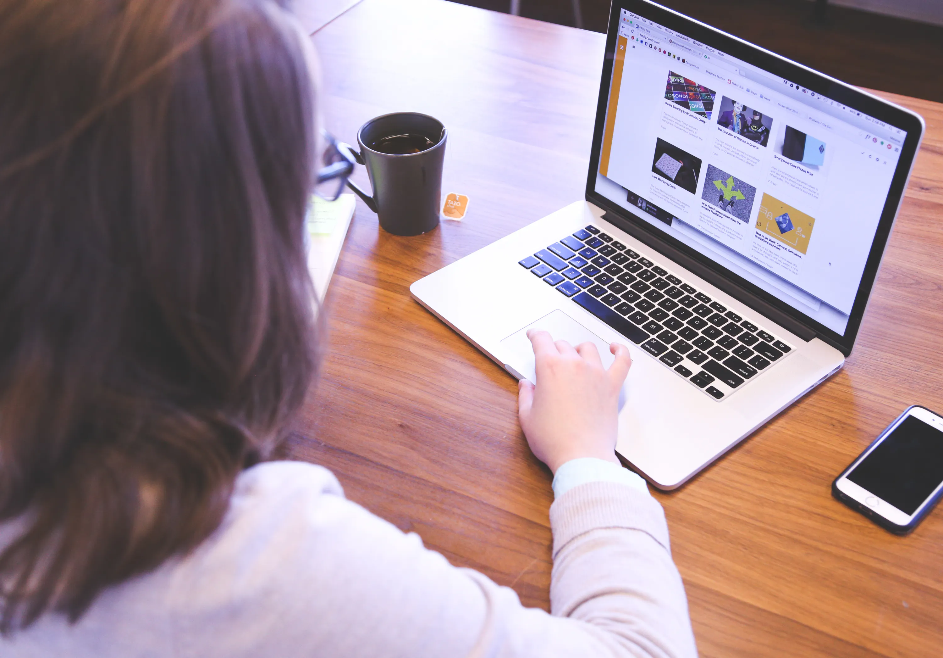 Person using an AI content writing tool on a laptop to improve writing productivity.