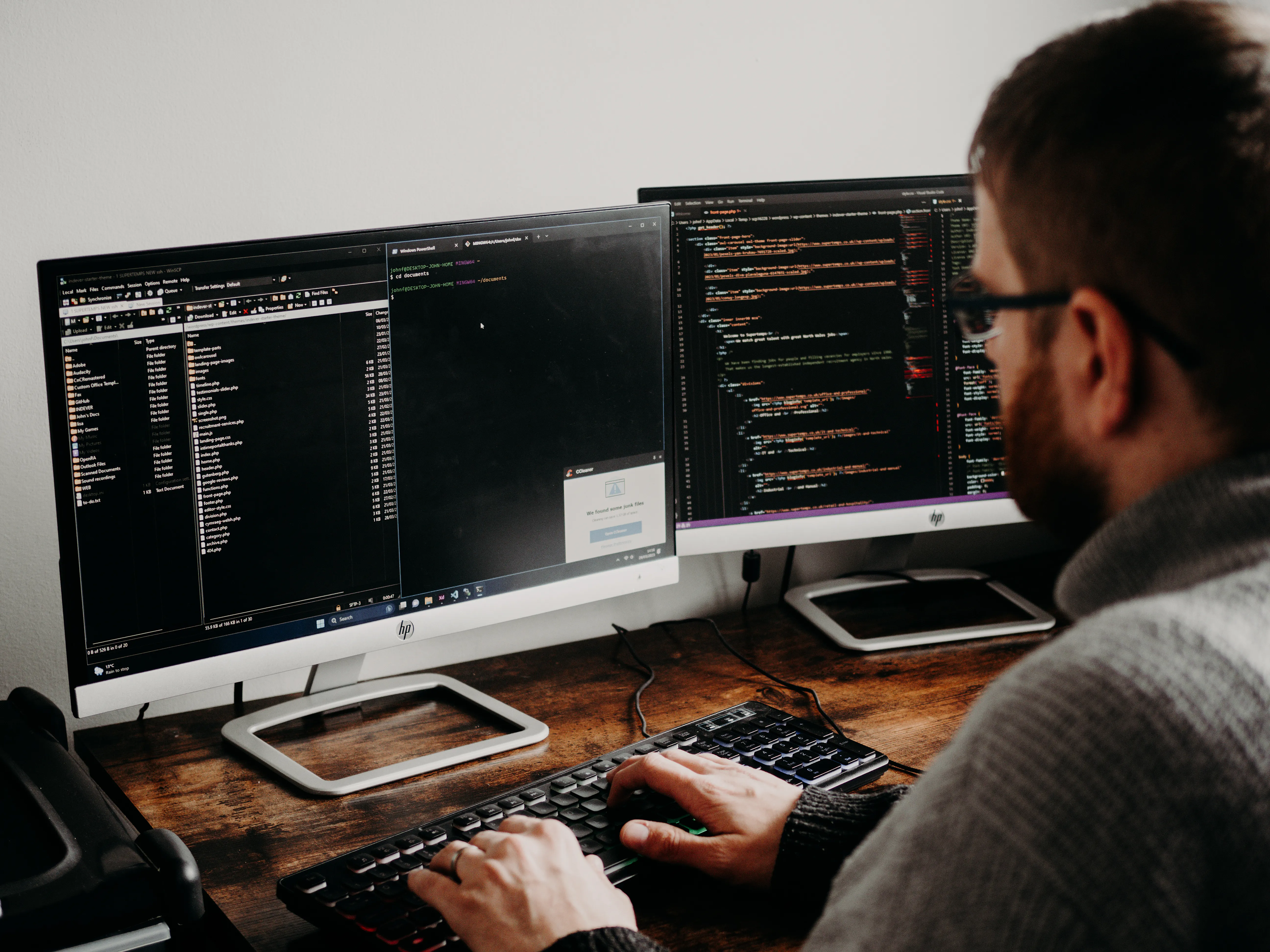 A developer typing code on dual monitors, optimizing for AI search engines.