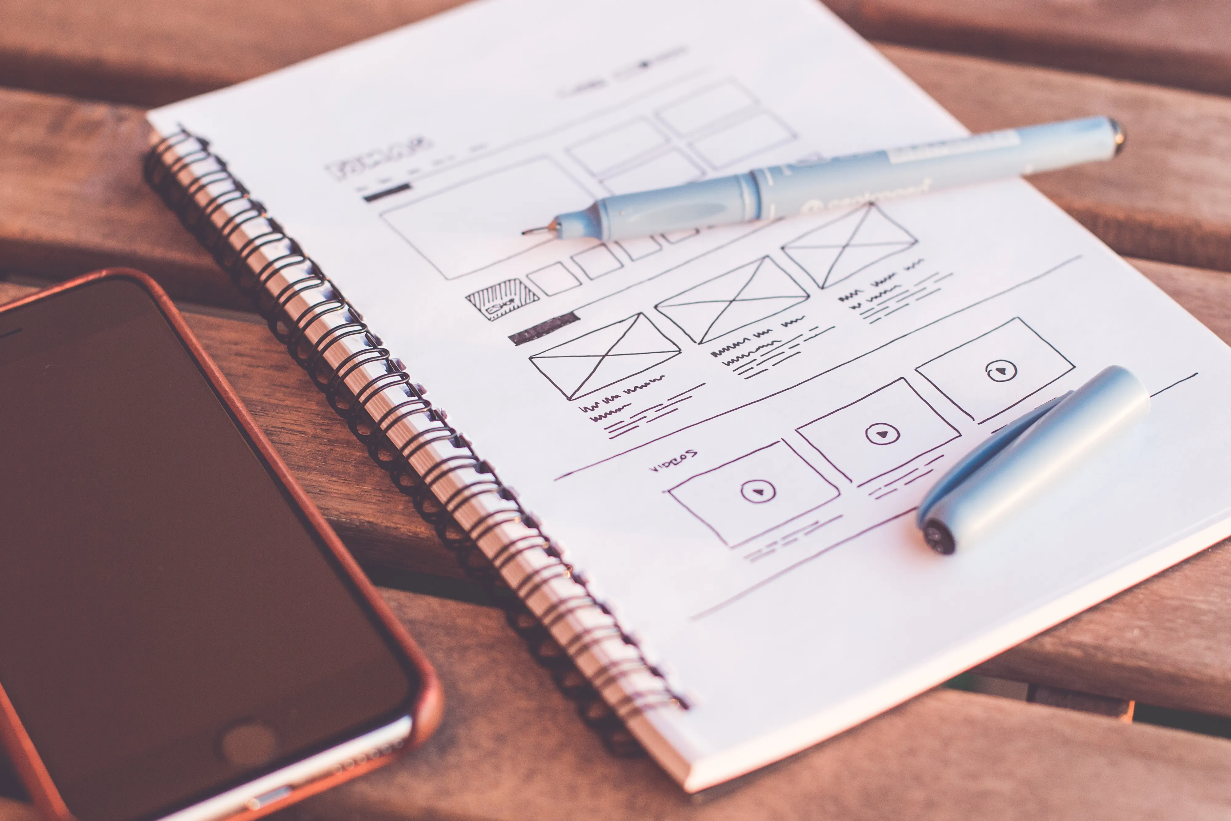 A wireframe sketch in a notebook with a phone, supporting your AEO SEO strategy.
