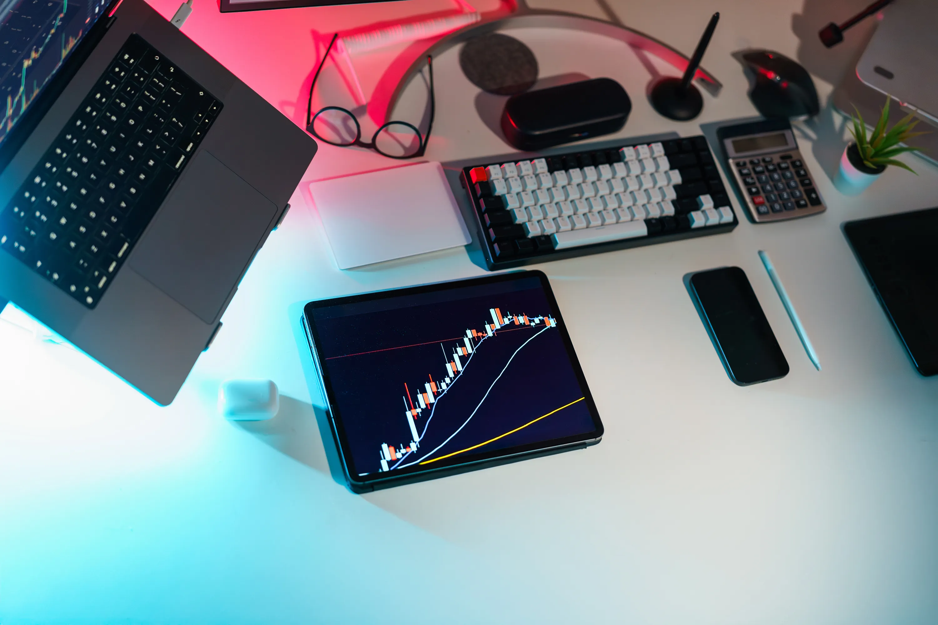 A high-tech desk setup with a laptop and tablet displaying financial charts for your content strategy for ai search.