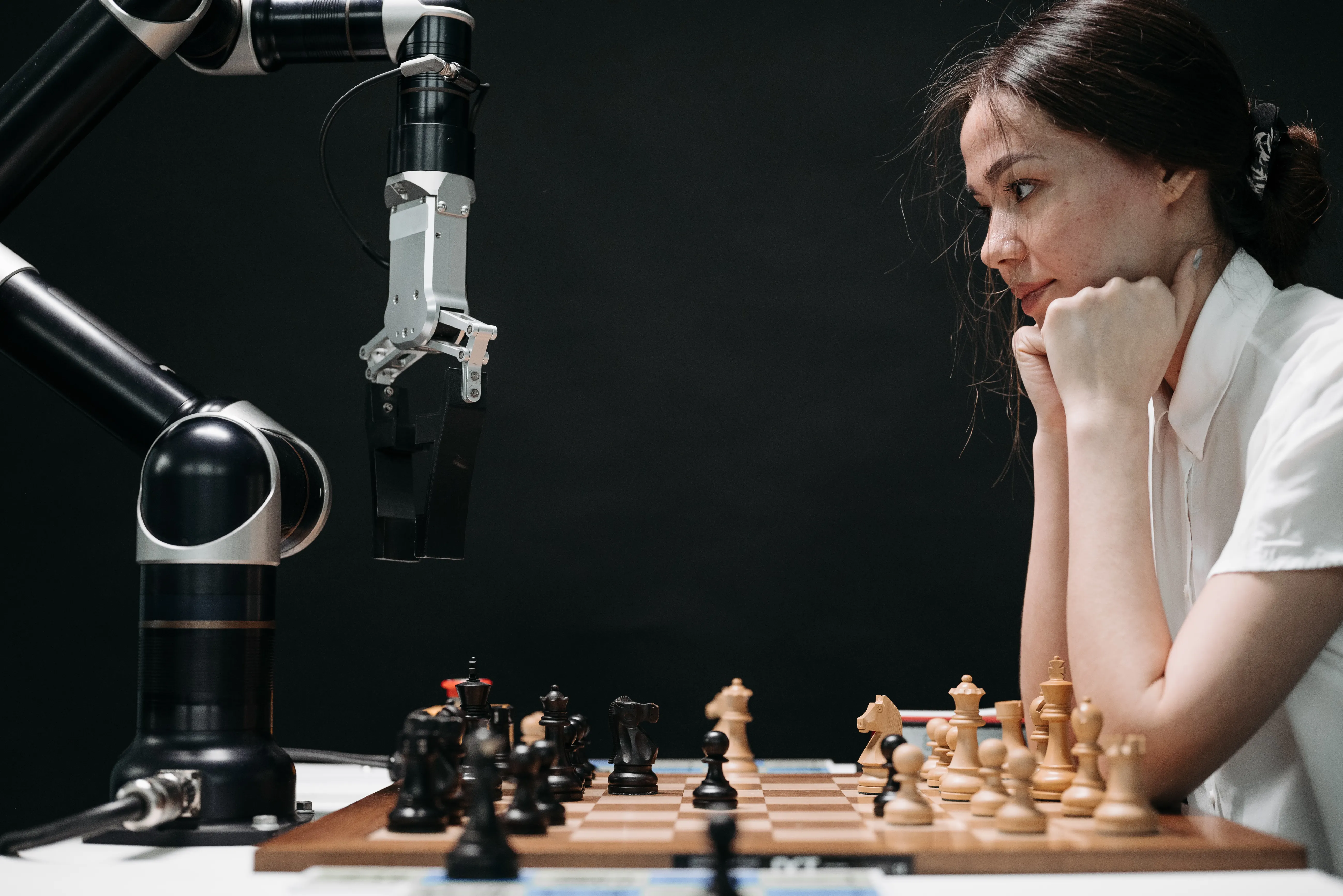 Woman playing chess against a robotic arm, demonstrating concepts related to generative engine optimization.