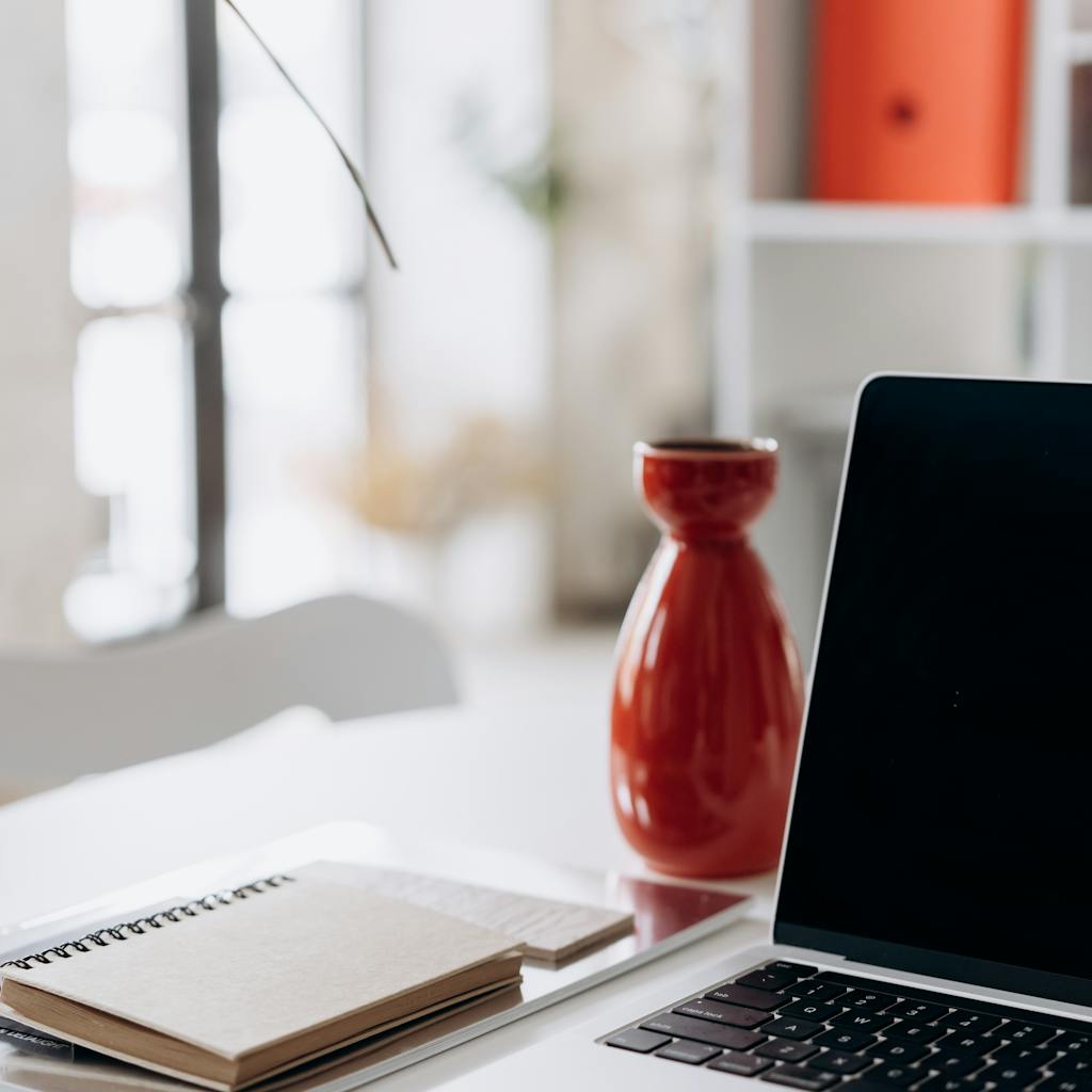 A vibrant, modern workspace featuring a person smiling and interacting with an AI writing tool on a laptop. The scene includes creative elements like sticky notes with blog ideas, a cup of coffee, and a well-lit, inspiring environment.